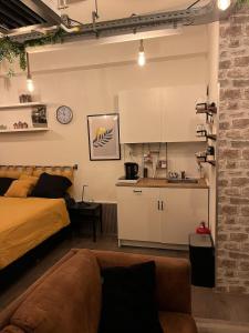a room with a bed and a kitchen with a couch at The Studio no windows 20 minutes by bus to downtown Amsterdam in Purmerend
