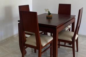 a wooden table with two chairs and a vase on it at Apartamento de lujo en Mocoa in Mocoa