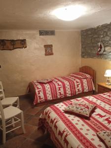a bedroom with two beds and a table and a chair at Maison Neige Et Soleil in Bionaz