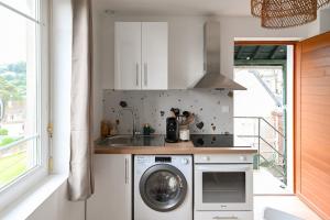 a kitchen with a washing machine and a sink at La Pinta - Fécamp in Fécamp +7 photos