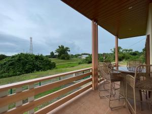 a balcony with a table and chairs and a view of a field at Balai Moca Hillside with Sunset View in San Juan