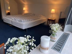 グリュックスブルクにあるFerienhaus Glücksburgのベッドと花がテーブルに飾られたホテルルーム
