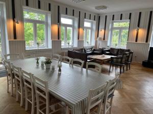 a dining room with a large table and chairs at Ferienhaus-am See in Glücksburg