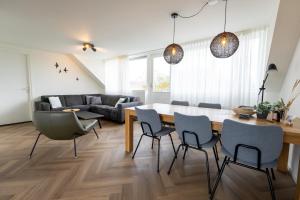 a living room with a dining room table and chairs at De Vrije wil in Buren