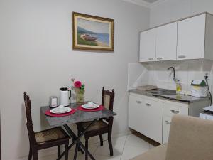 a small kitchen with a table with two plates on it at Apê 02 - confortável e perto de tudo in Vitória da Conquista