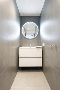 a bathroom with a white sink and a mirror at De Vrije wil in Buren