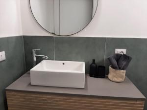 a bathroom with a white sink and a mirror at Appartamento Santa Maria Nuova in Reggio Emilia +5 photos