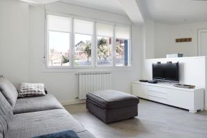a living room with a couch and a flat screen tv at BALENTZIAGA Getaria in Getaria +26 photos