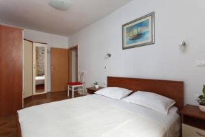 a bedroom with a white bed and a red chair at Old Town Apartment Mila in Split