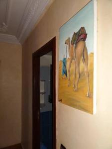 a painting of a camel hanging on a wall at Manis Apartment Set in a Hotel Area in Marrakesh