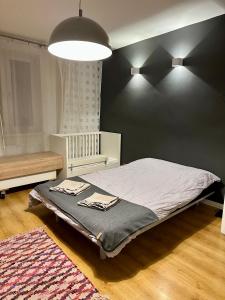 sypialnia z łóżkiem i czarną ścianą w obiekcie Brynów Point w mieście Katowice