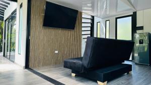 a black chair in a room with a tv on a wall at Cabaña Guadalajara Glamping in Moniquirá