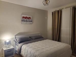 una camera da letto con un letto e un quadro sul muro di Emmas Place- Apartamenti modern por miqesor ne qender te Elbasanit a Elbasan