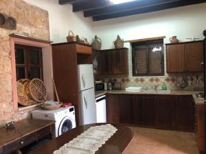 a kitchen with a white refrigerator and a table at Zivlas Stone House in Trimitusa