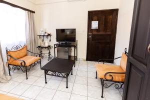 sala de estar con TV, sillas y puerta en Hotel Camino Maya, en Copan Ruinas