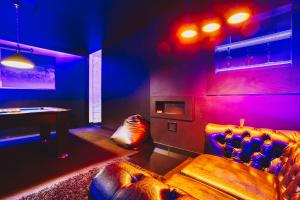 a room with a couch and a table with purple lights at Midnight Old Town in Bydgoszcz