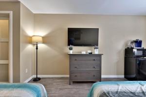 una camera con 2 letti, una TV e un comò di Your Perfect Getaway Renovated and Beautifully Decorated Hotel Room Studio a Killington