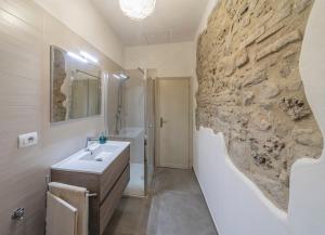 bagno con lavandino e parete in pietra di Cuore di vigna in Umbria a Cenerente