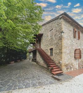 un edificio in pietra con una scala sul lato di Cuore di vigna in Umbria a Cenerente
