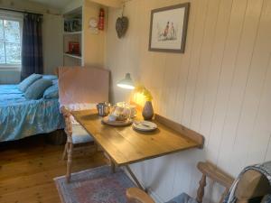 a room with a wooden table with a bed and a table sidx sidx sidx at Phoenix Farm Shepherds Hut in Liskeard