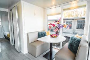 a living room with a table and chairs and a window at Unique new house boat near Giethoorn in Zwartsluis