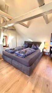 a large bed in a room with wooden floors at Ysenberc Apartments in Moritzburg