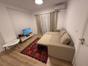 a living room with a couch and a television at Klito`s Home in Krujë