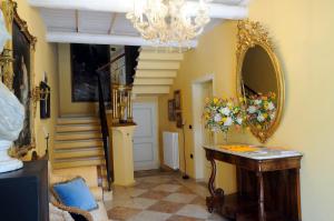 una habitación con espejo y una mesa con flores. en B&B A Casa Dell'Antiquario, en San Benedetto Po