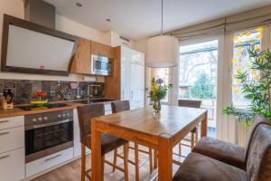 una cucina con tavolo e sedie in legno di Apartment Hannover Top Citylage ad Hannover