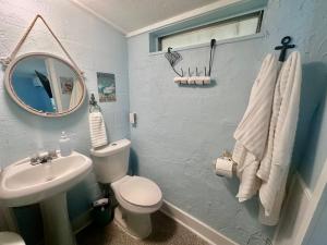 a bathroom with a sink and a toilet and a mirror at Neptune's Grotto Old Florida Adventure Retreat in Spring Hill +43 photos