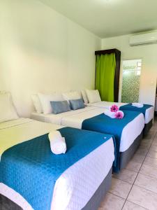 a room with three beds with blue and white at Canto das Laranjeiras Vista Way in Guarujá