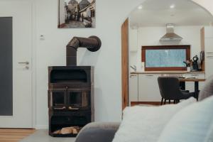 a living room with a stove and a kitchen at EifelNest Blankenheim in Blankenheim
