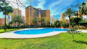 a swimming pool in a park with tall buildings at SUNSET Chill Out- Torres D' Oboe in Benidorm