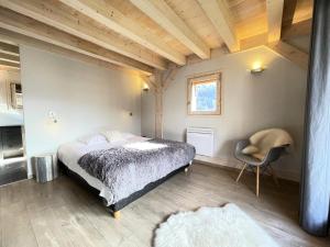 une chambre avec un lit et une chaise dans une pièce dans l'établissement Résidence Grenier De Koikoi - Chalet de standing : Grenier de Koikoi MAE-2404, à Notre-Dame-de-Bellecombe