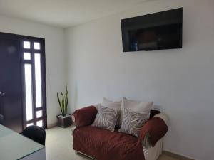a living room with a red couch and a flat screen tv at GR20acd Doris in Cuauhtémoc