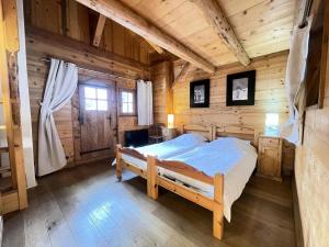 a bedroom with a bed in a log cabin at Résidence Les Greniers - Chalet typique dans un environnement de charme MAE-5664 in Notre-Dame-de-Bellecombe