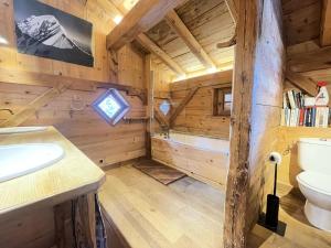 a log cabin bathroom with a toilet and a tub at Résidence Les Greniers - Chalet typique dans un environnement de charme MAE-5664 in Notre-Dame-de-Bellecombe