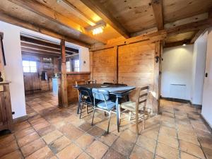 a dining room with a black table and chairs at Résidence Les Greniers - Chalet typique dans un environnement de charme MAE-5664 in Notre-Dame-de-Bellecombe +9 photos