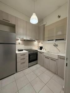 a kitchen with stainless steel appliances and a sink at Hidden Gem Apartment in Patra