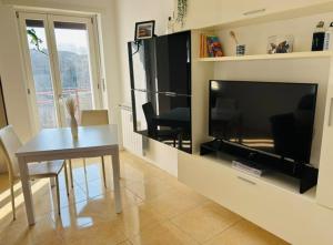 a living room with a table and a large television at Spazioso appartamento, ampio parcheggio, vicino Valle d'Aosta in Banchette