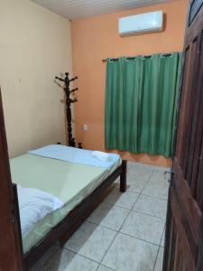 a room with two beds and a green curtain at Quartos em Alter do Chão in Santarém