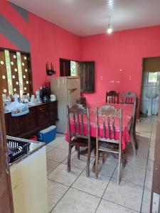 a kitchen with a table and a red wall at Quartos em Alter do Chão in Santarém