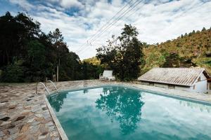 a swimming pool with a chair next to a house at Sítio D Ouro in Marechal Floriano