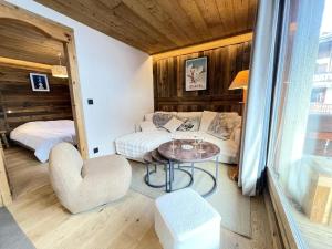 Pokój z kanapą, stołem i łóżkiem w obiekcie Résidence Les Oursons - Appartement de charme au pied des pistes de l'Espace Diamant MAE-6464 w mieście Notre-Dame-de-Bellecombe