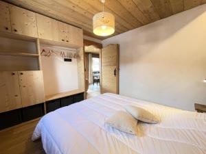 sypialnia z białym łóżkiem i drewnianymi szafkami w obiekcie Résidence Les Oursons - Appartement de charme au pied des pistes de l'Espace Diamant MAE-6464 w mieście Notre-Dame-de-Bellecombe