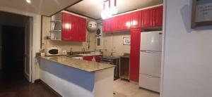 a kitchen with red cabinets and a white refrigerator at Aqua Maadi Degla Group 199 in Cairo
