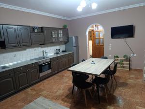 a kitchen with a wooden table and chairs in it at Savvas&Katia's luxury house in Mantoúkion