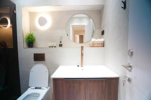 a bathroom with a sink and a mirror and a toilet at alma in Eilat