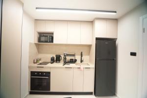 a kitchen with white cabinets and a black refrigerator at alma in Eilat +11 photos