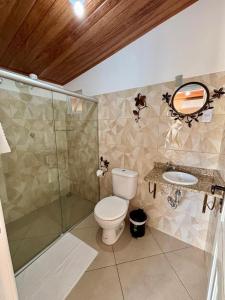 a bathroom with a toilet and a shower and a sink at Pousada Roncador in Lençóis